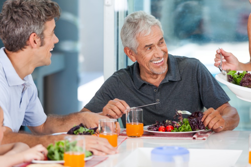 Older men eating healthy vegetables and drinking juice.