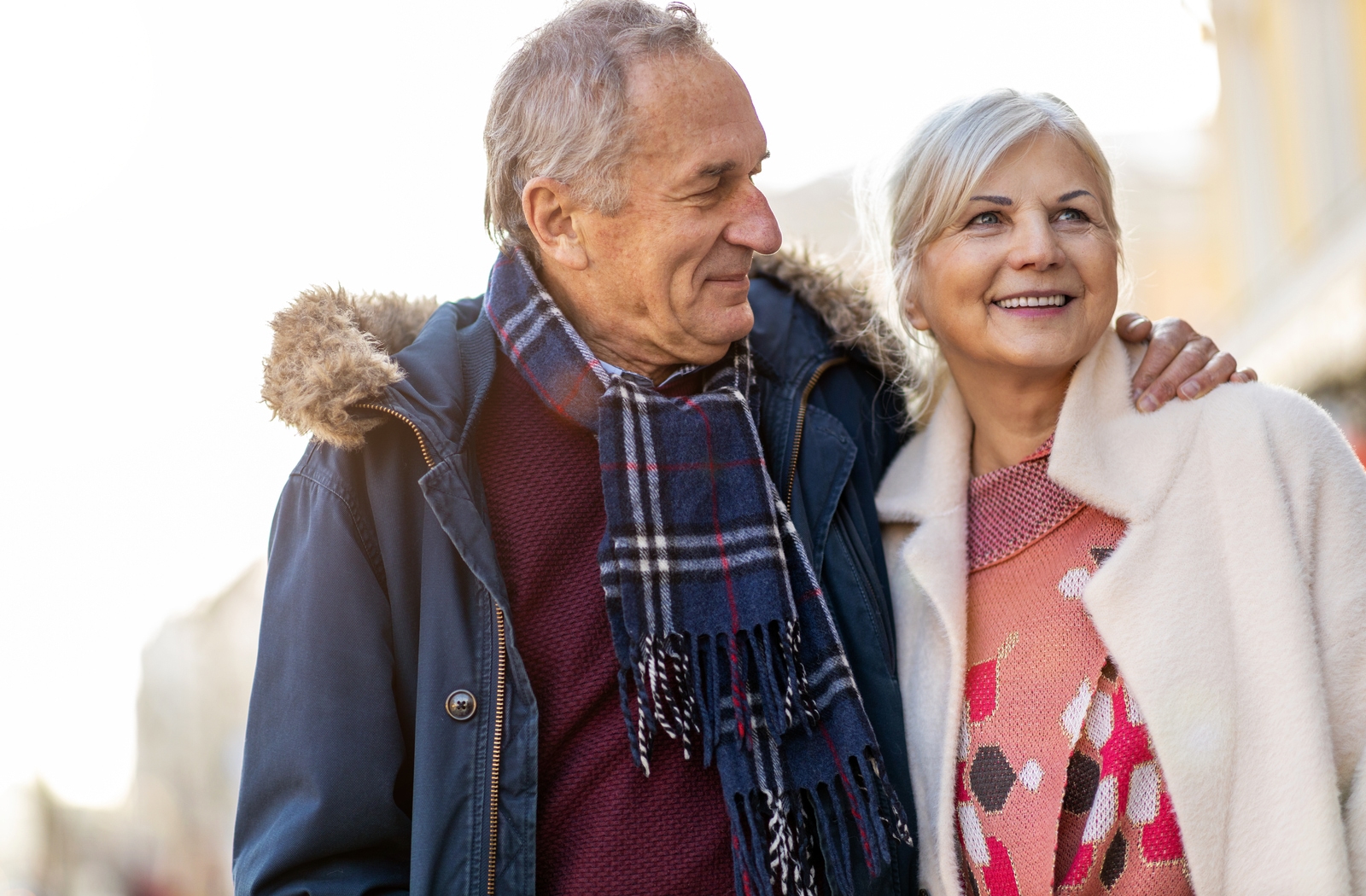 A senior couple dressed in warm clothing, out for a walk on a sunny winter's day